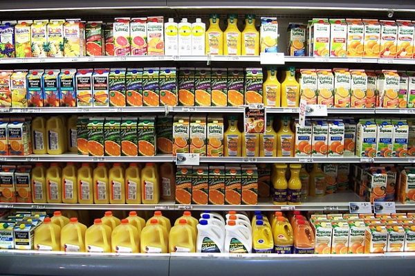 shelves of juice cartons in refrigerated section of store