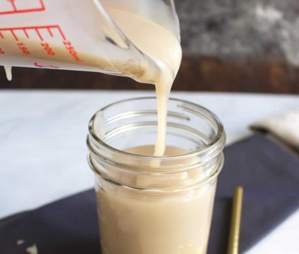 pouring condensed milk into a jar