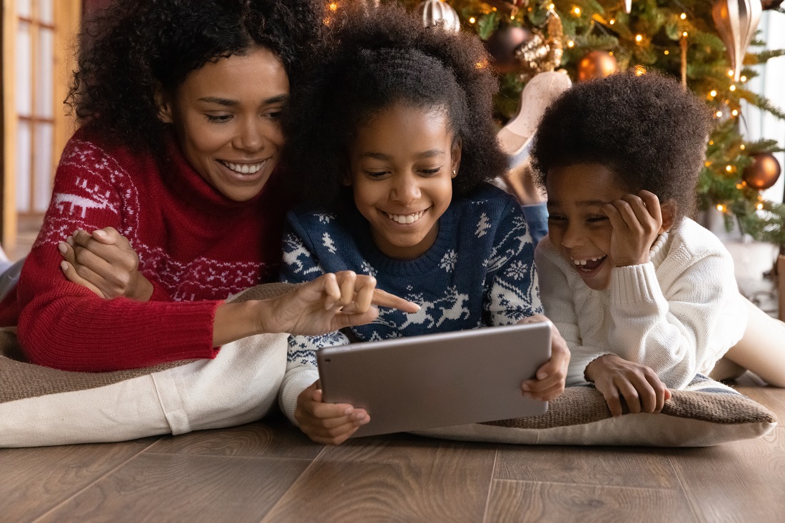 Mother and two kids using tablet PC to select Christmas gifts