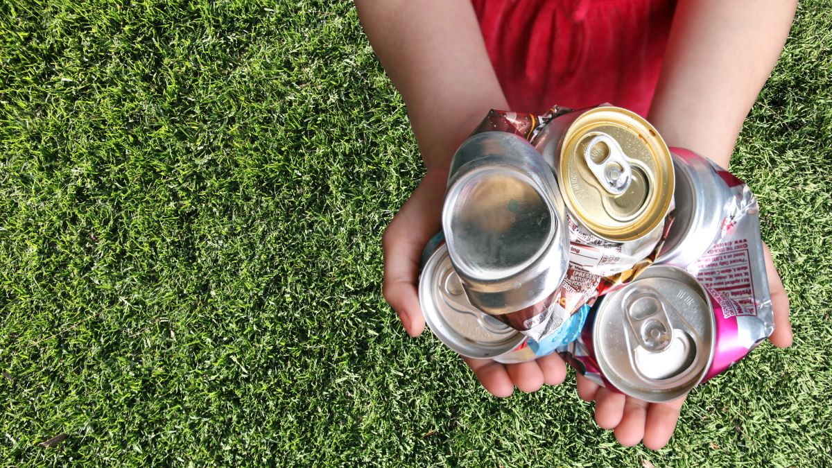 Child's hands holding crushed aluminum cans