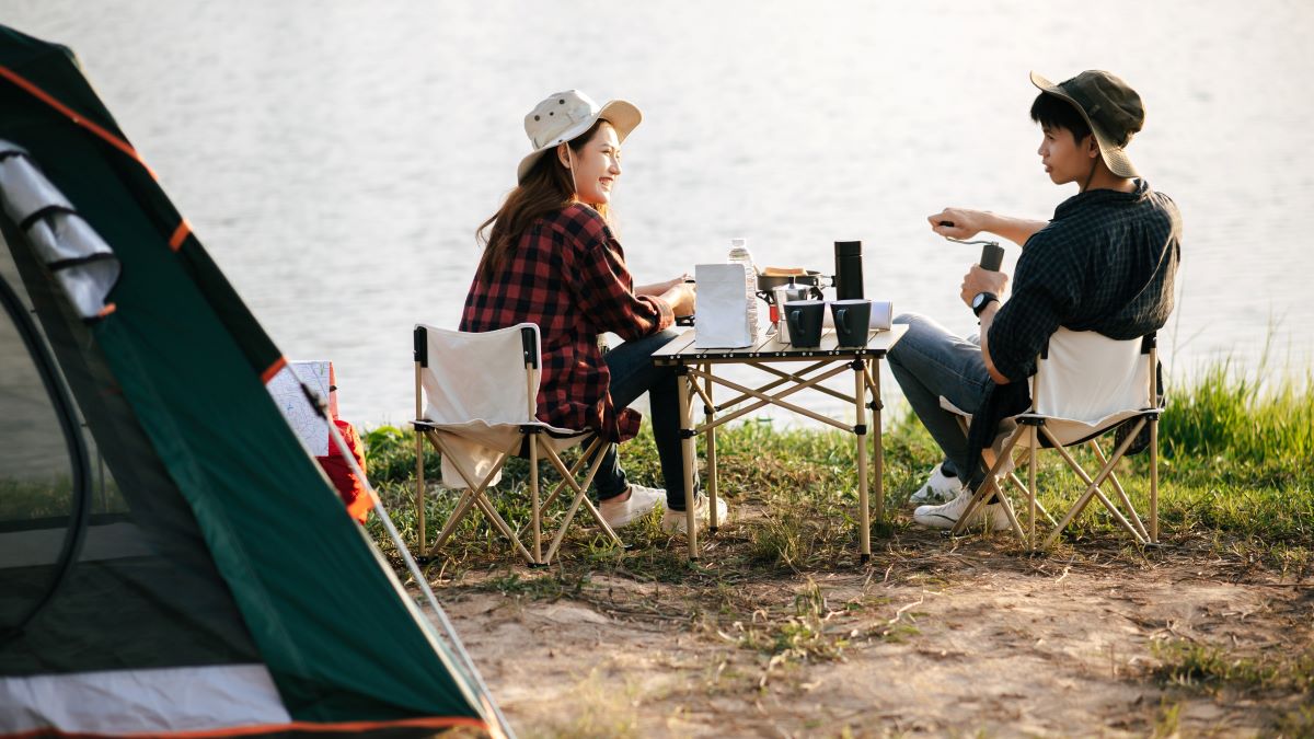Young couple camping with morning coffee