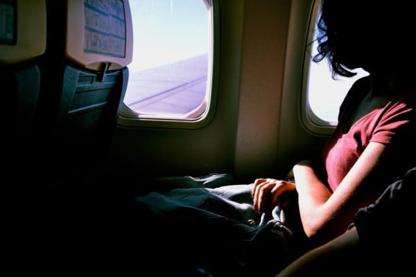 woman passenger looking out airplane window