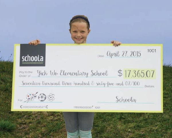 Young child holding Schoola fundraising check