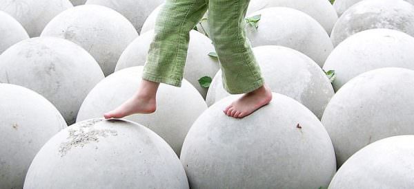 Child Walking on White Round Spheres