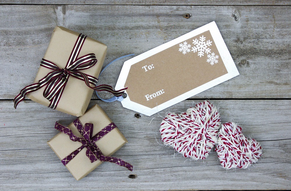 Gift tag, presents and rope hearts on rustic background