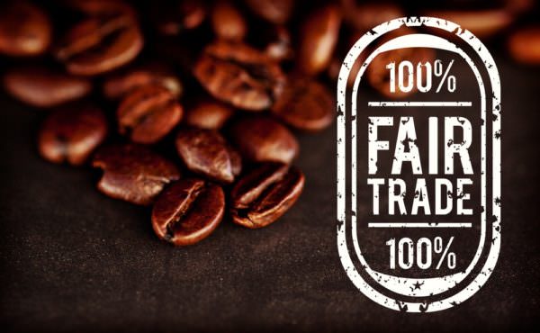 Fair Trade graphic against dark blurred coffee seeds