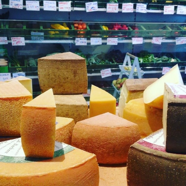 Wheels of cheese and produce. Image credit: originalunverpackt, Instagram