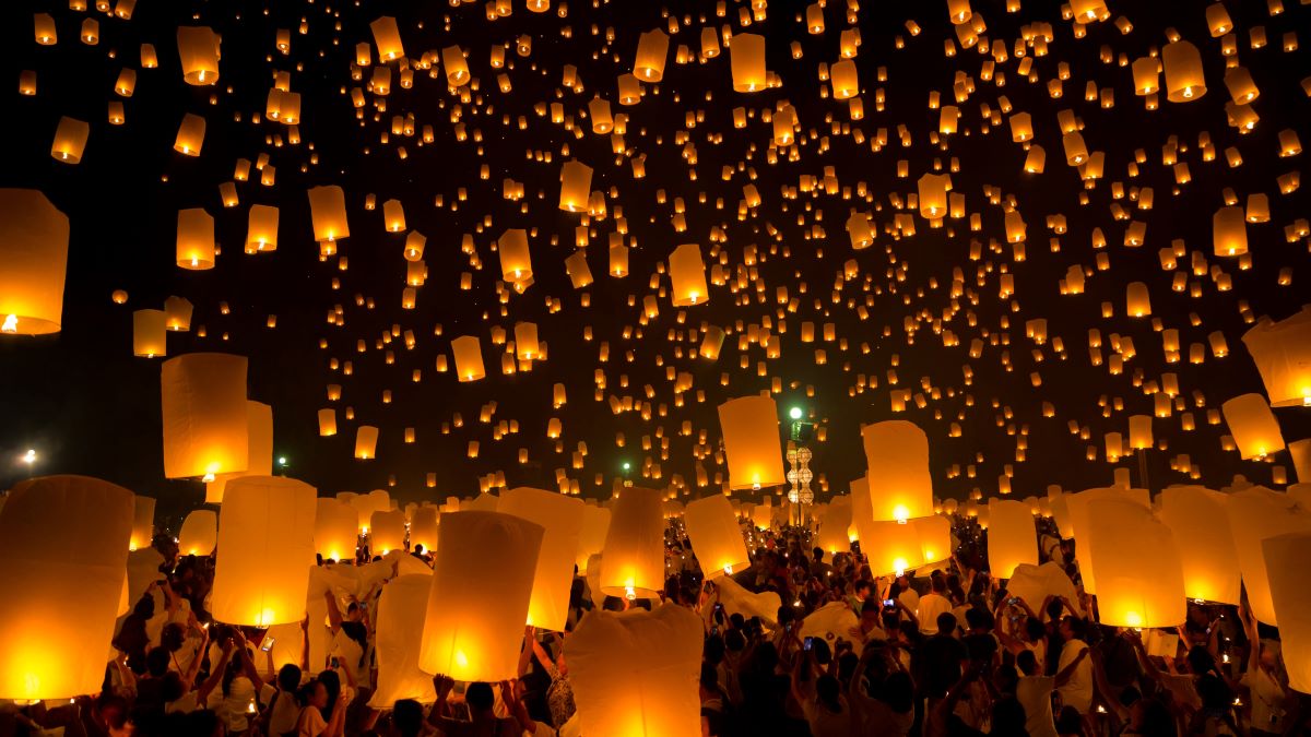 Large group of people releasing sky lanterns at night
