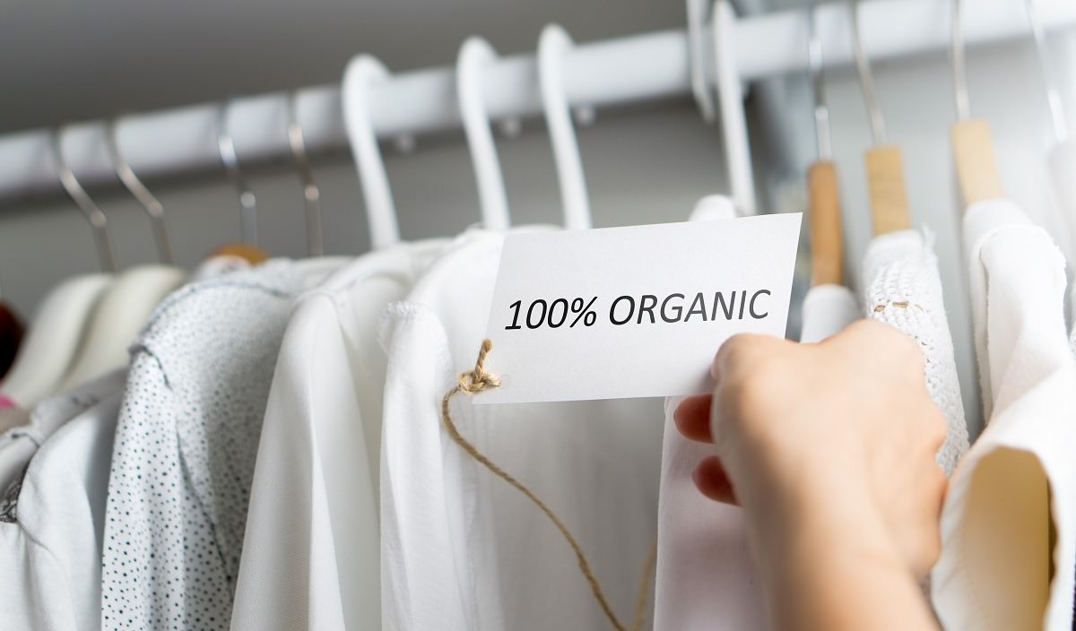 100% organic clothing hanging on rack in store
