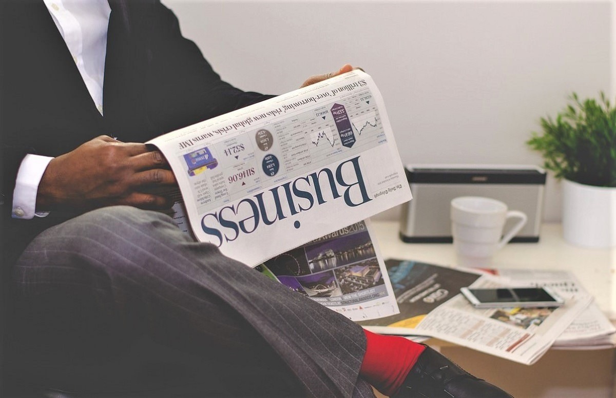 man reading business section of newspaper