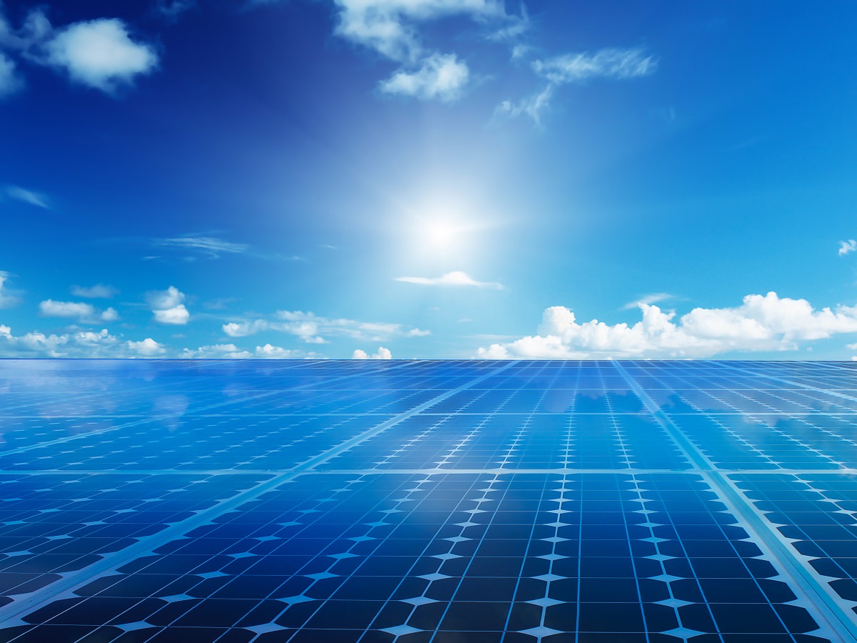 Solar photovoltaic panels with bright sun, blue sky background
