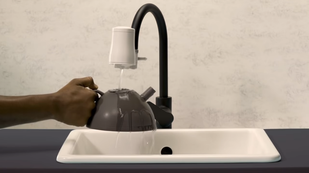 Filling teapot with water filtered through Tapp Water faucet filter