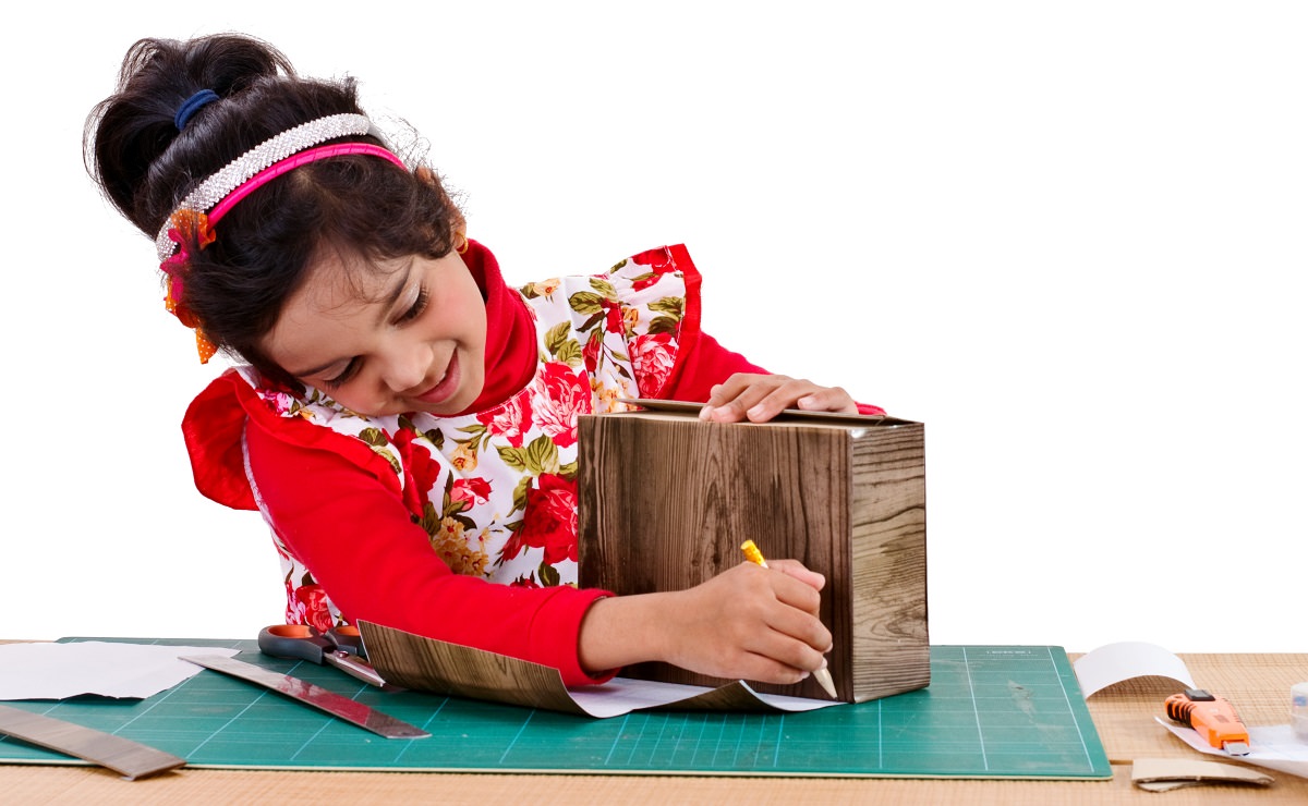 girl working on craft project with box