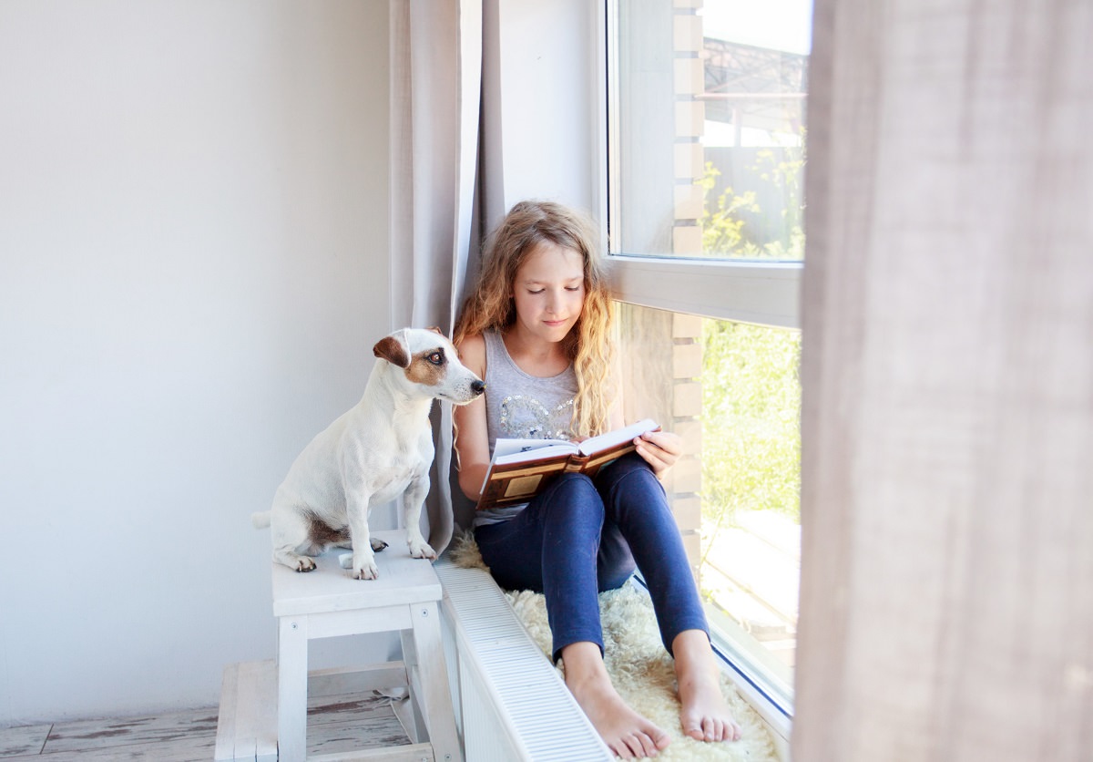 girl sitting at window reading