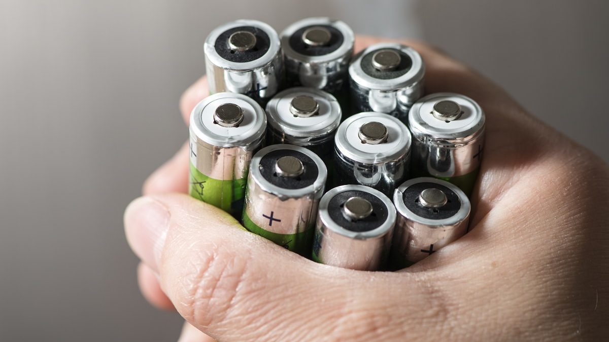 Hand holding several batteries