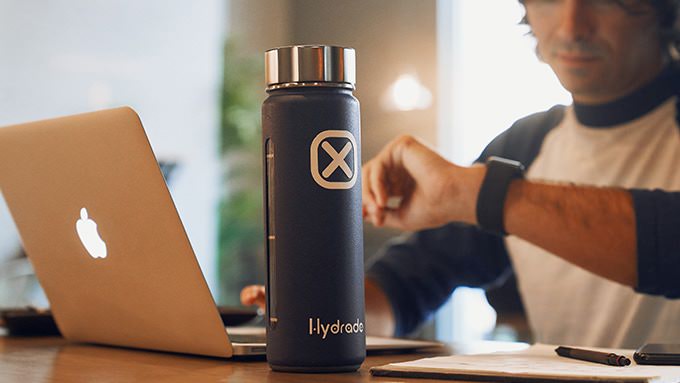 Man at desk with Hydrade smart water bottle