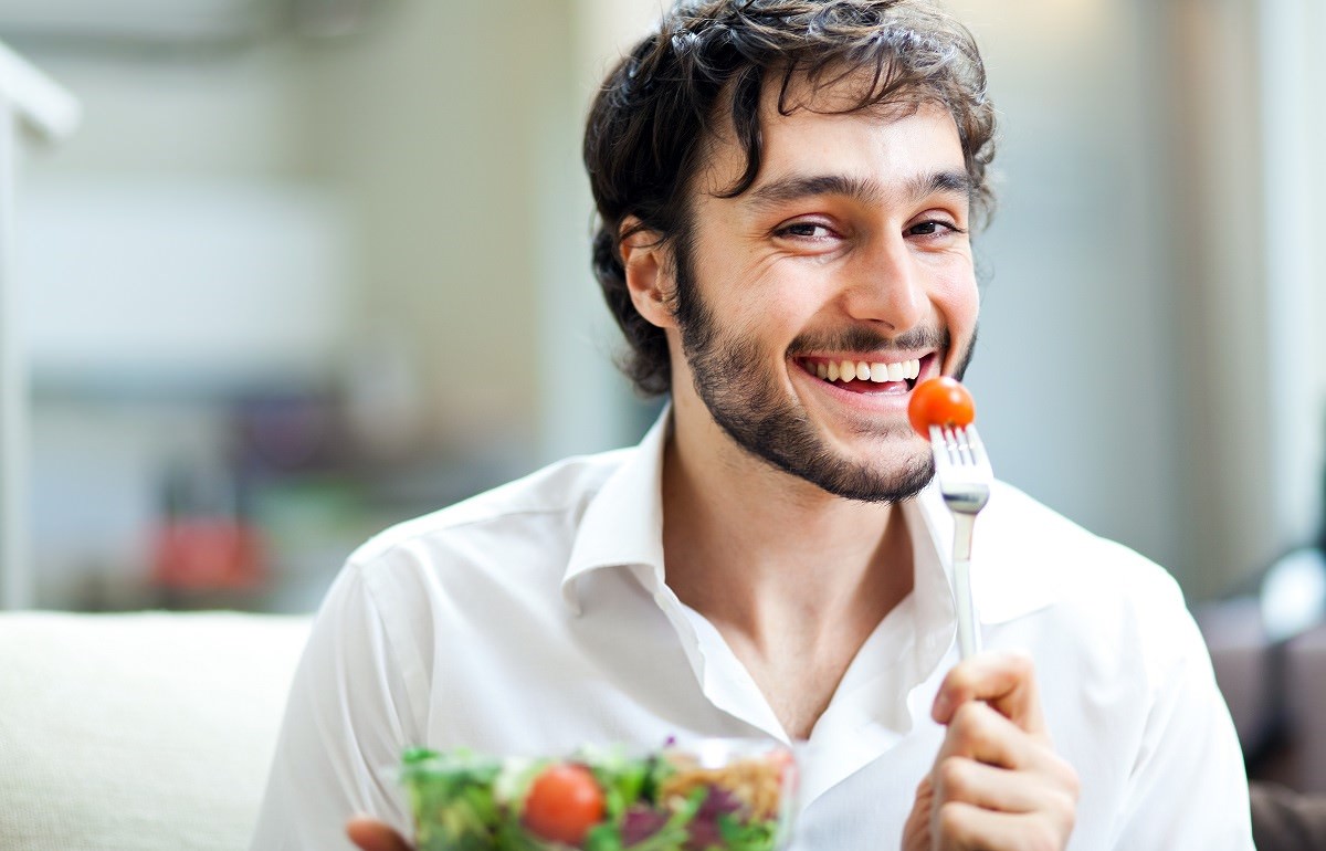 smiling man eating salad
