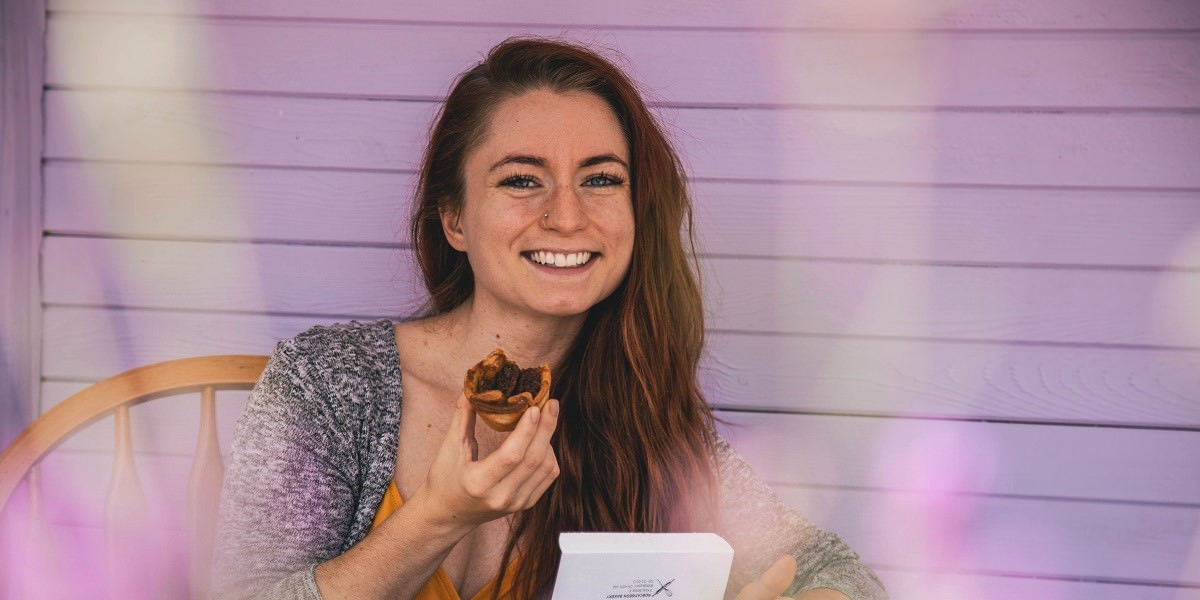 smiling young woman holding pastry