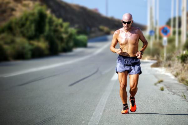 shirtless man, running by roadside