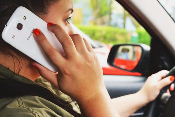 Woman talking on smartphone while driving car