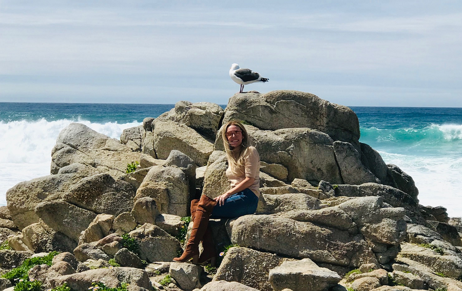 Lisa Beres sitting on rocks on California's Pacific coast