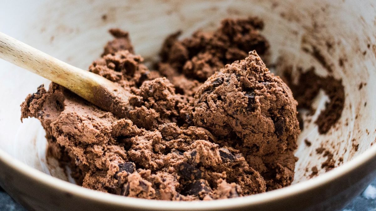 bowl of chocolate cookie batter, wooden spoon