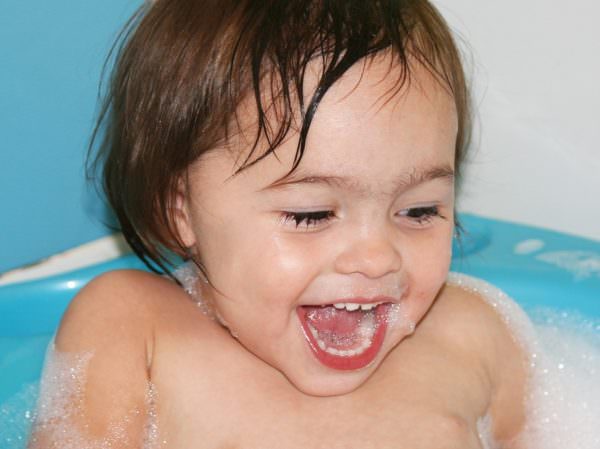 laughing toddler in bubble bath