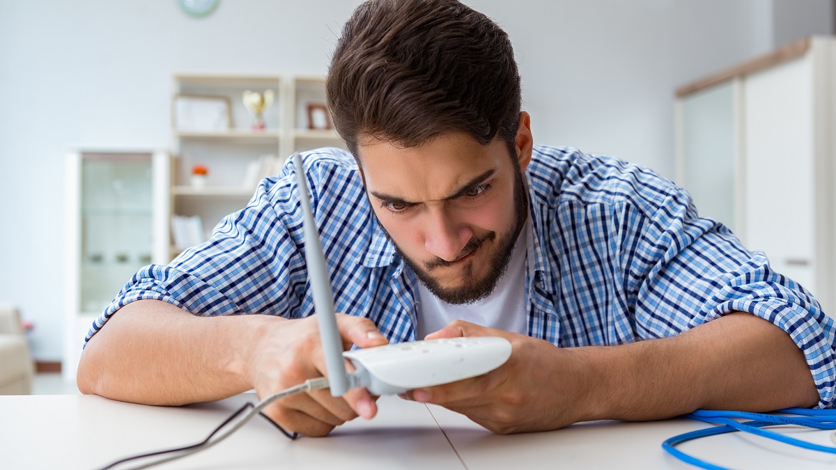 frustrated young man holding internet router