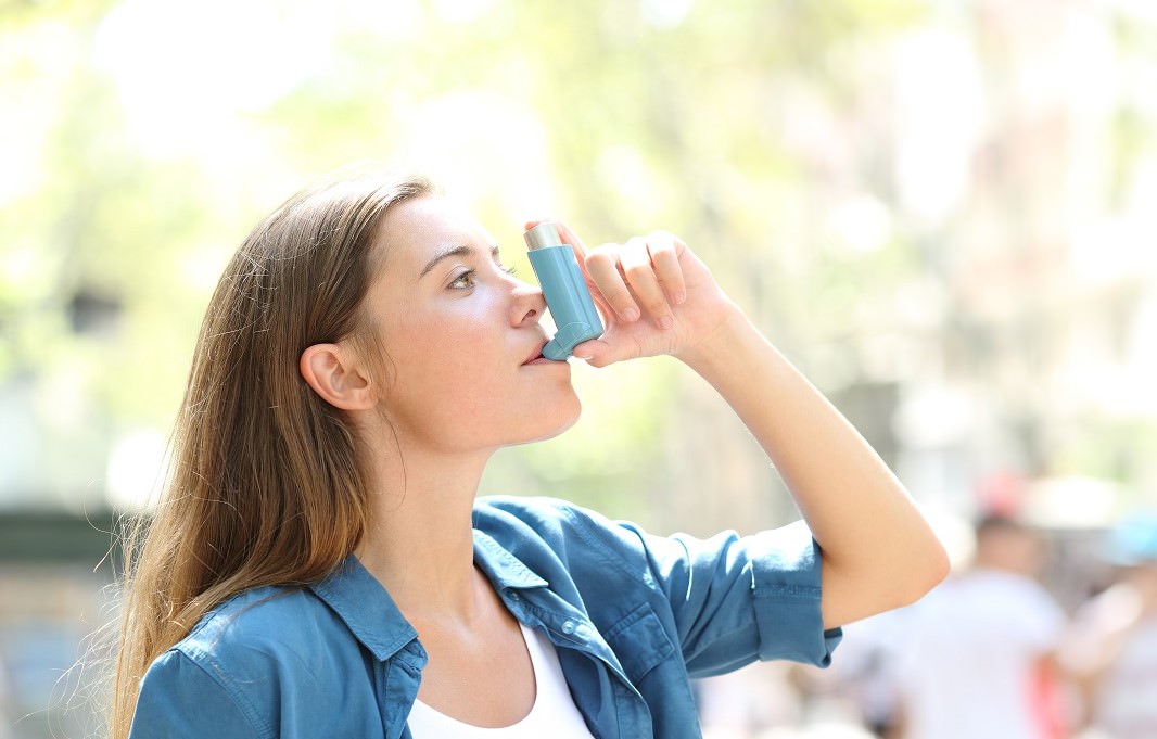woman using an inhaler for asthma