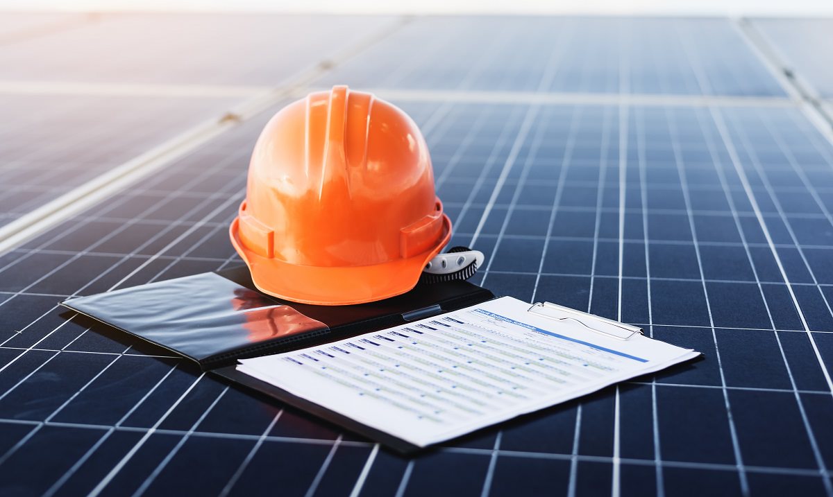 hard hat and contract on solar panel