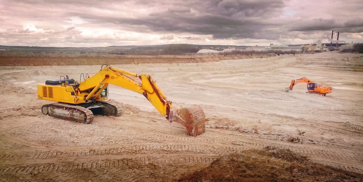 excavators in open cast mine, devastated landscape