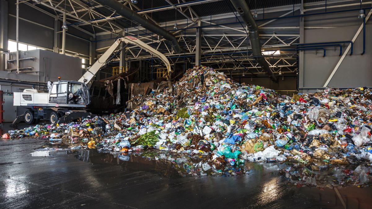Excavator sorts waste at waste processing plant