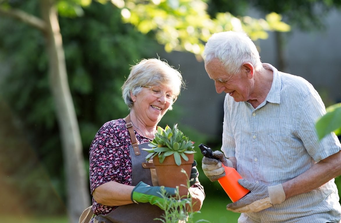 senior couple potting plant outside