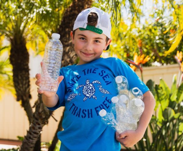 Ryan holding plastic bottles and wearing Sand Cloud T-shirt