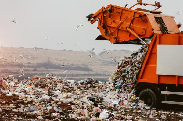 garbage truck dumping trash in landfill