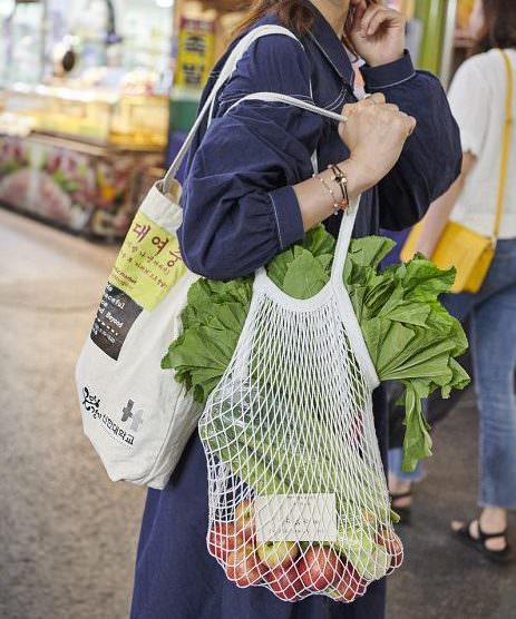 woman shopping with reusable cloth and string bags