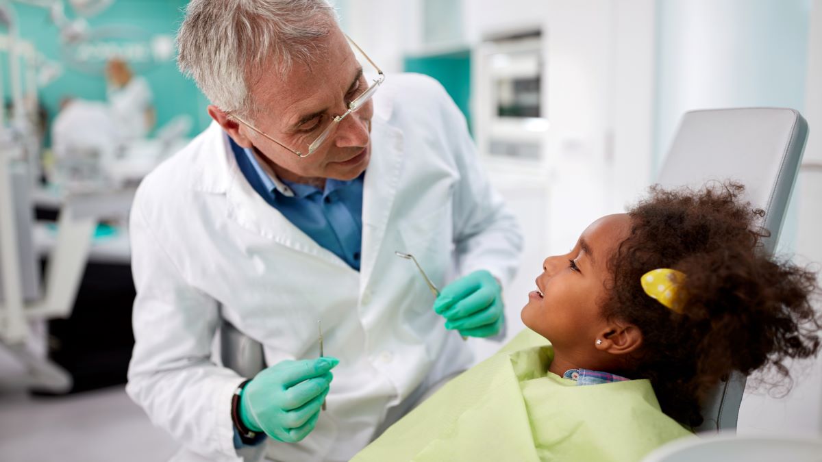 dentist talking to child in dental chair
