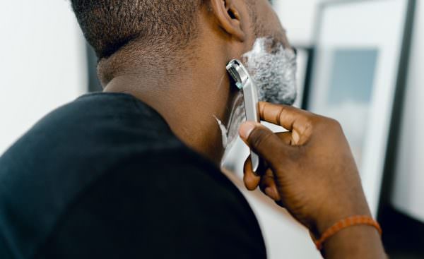 man shaving with reusable metal safety razor