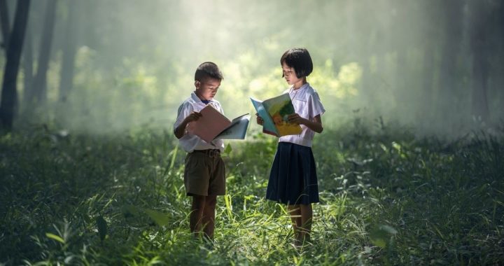 boy and girl reading books in forest