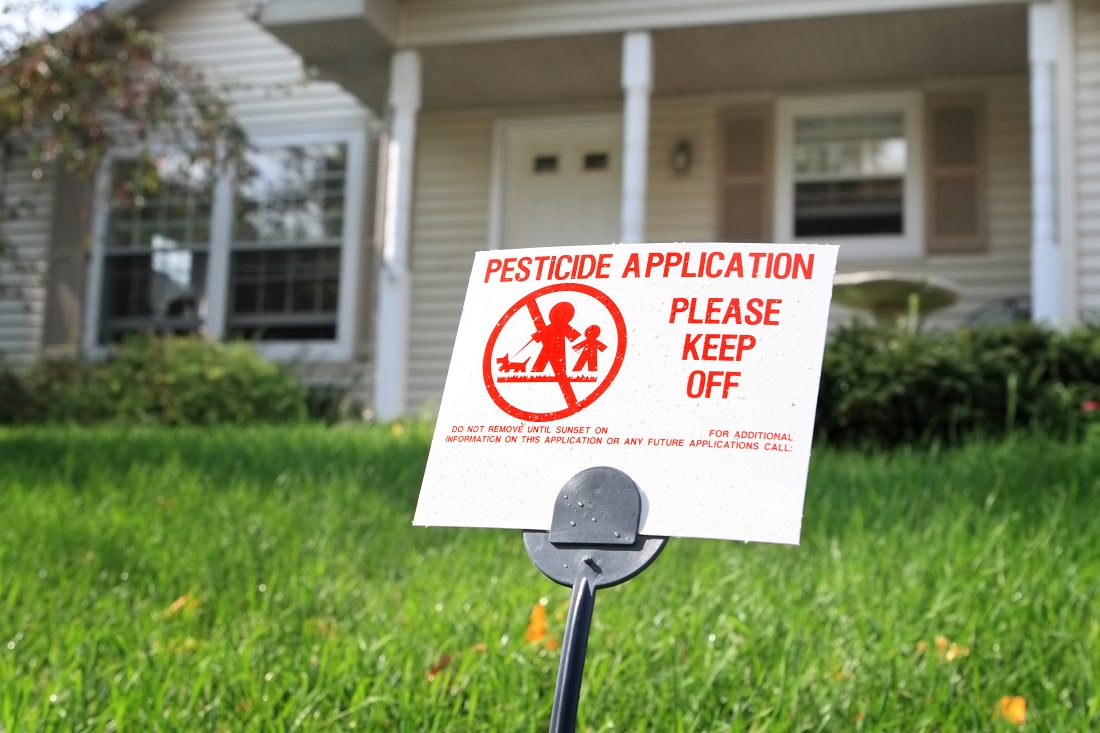 pesticide warning sign in home's front lawn