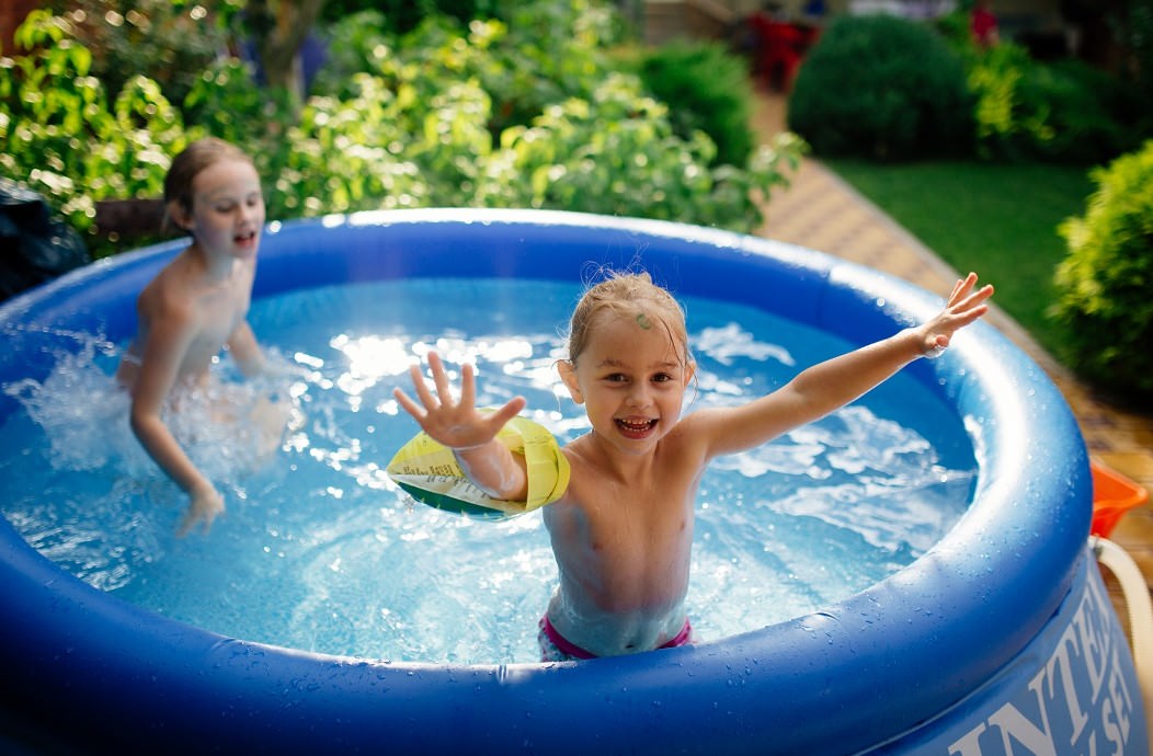 Two little girls playing in a kiddie pool