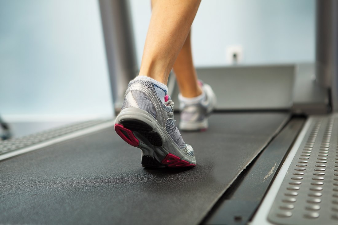 Close-up of woman's feet walking on treadmill