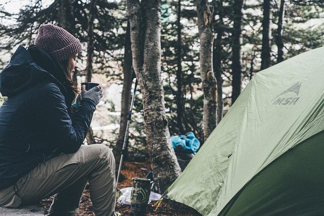 Woman sitting at campsite wearing synthetic clothing