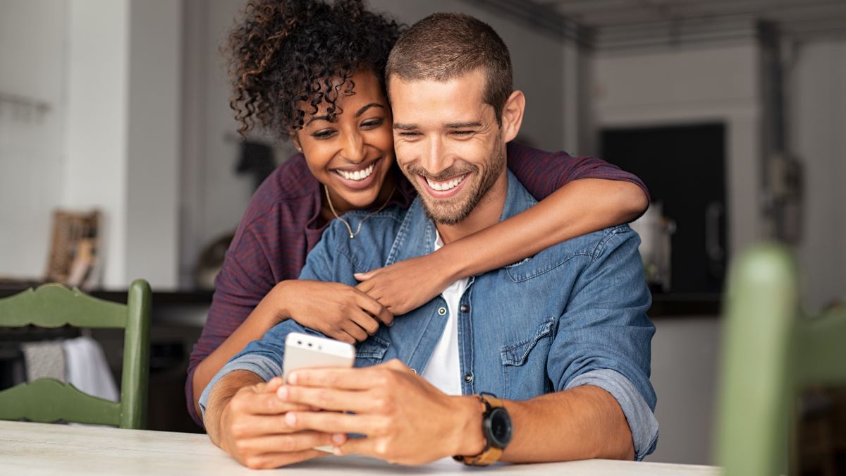 Smiling couple looking at mobile app on a phone