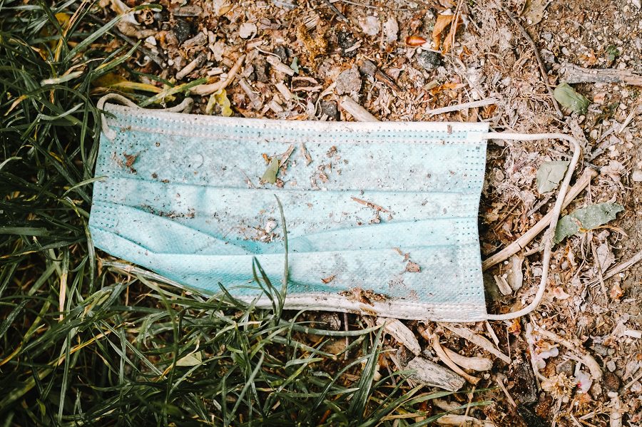 disposable face mask lying in the grass