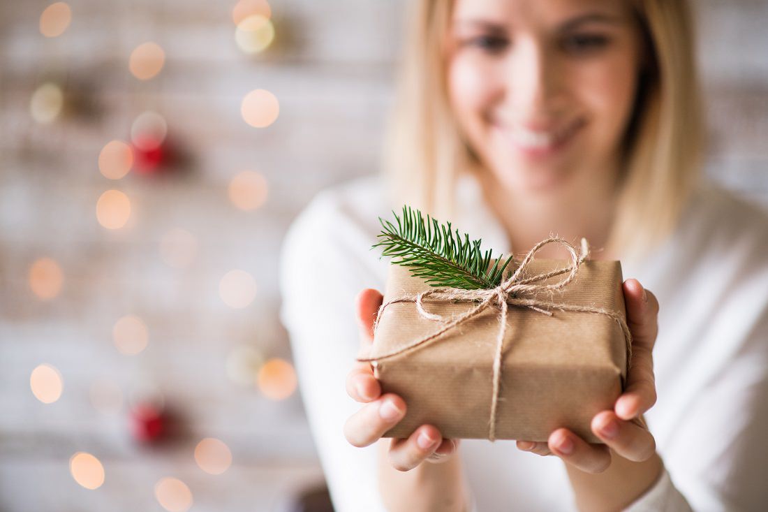 smiling young woman holds holiday gift