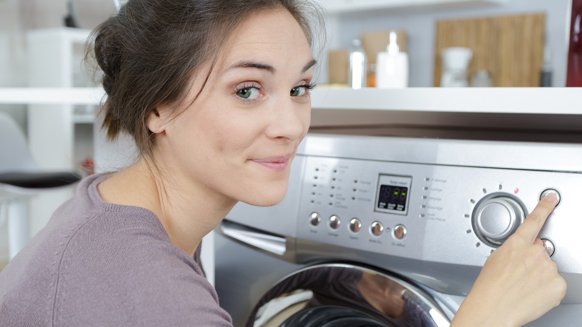 woman turning on the clothes washing machine