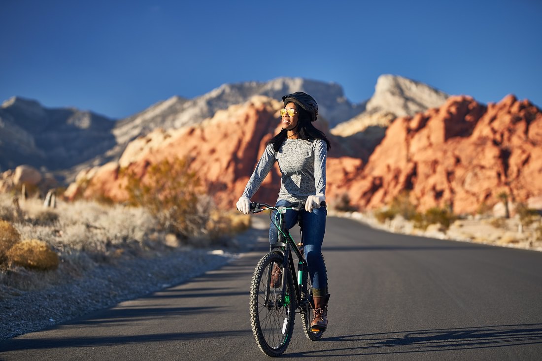 woman riding bike through red rock country