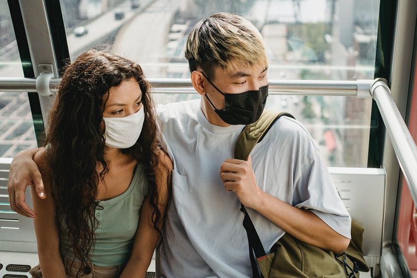 Young couple in cloth masks on public transit