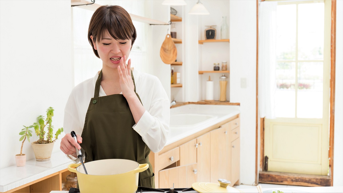 woman at stove realizing she made a mistake in cooking